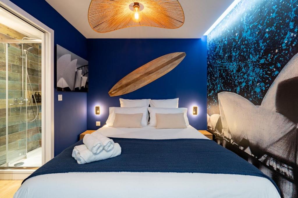 a blue bedroom with a bed with towels on it at Air Nomad • Sydney in Valenciennes