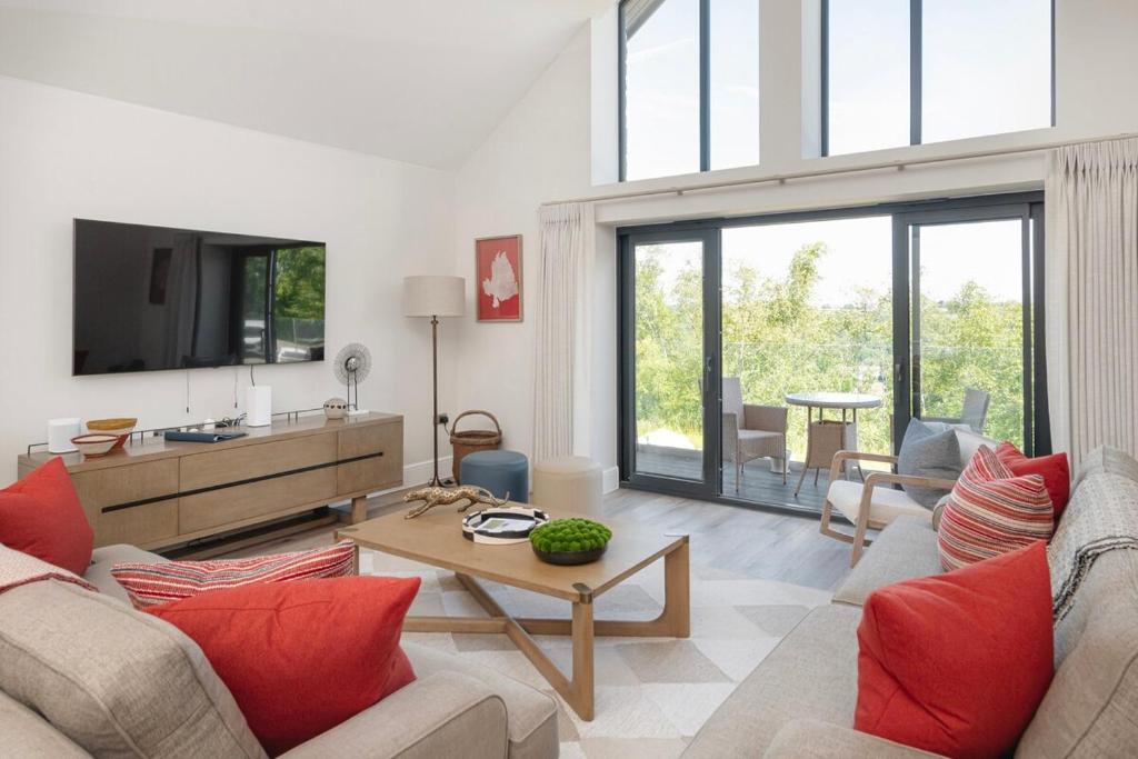 a living room with a couch and a tv at Hill View House - Cookswood in Holcombe