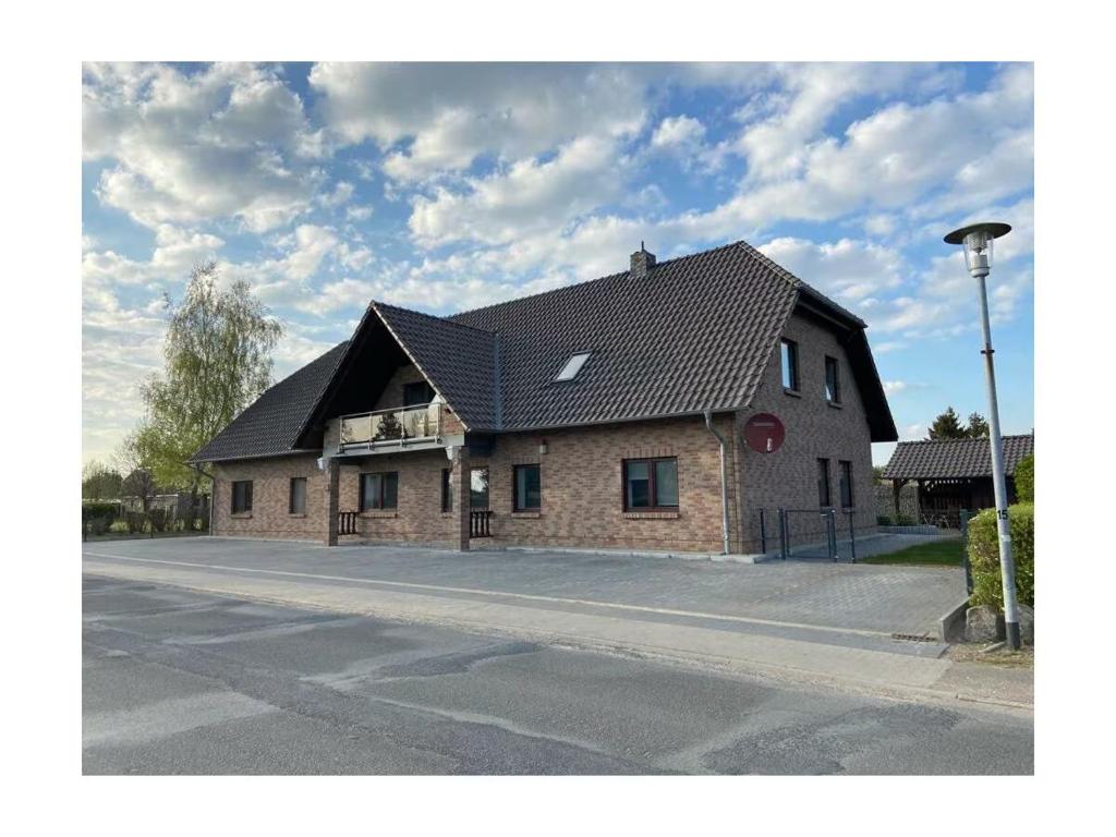 a brick house with a black roof on a street at FeWo Igelnest ID 16292-0 in Kargow