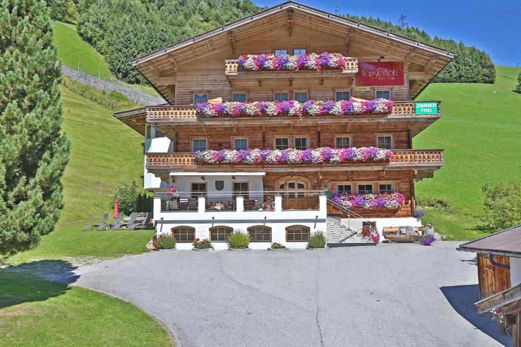 a large building with flowers on top of it at Hotel Garni Hanslerhof " Urlaub am Bauernhof " in Gerlos
