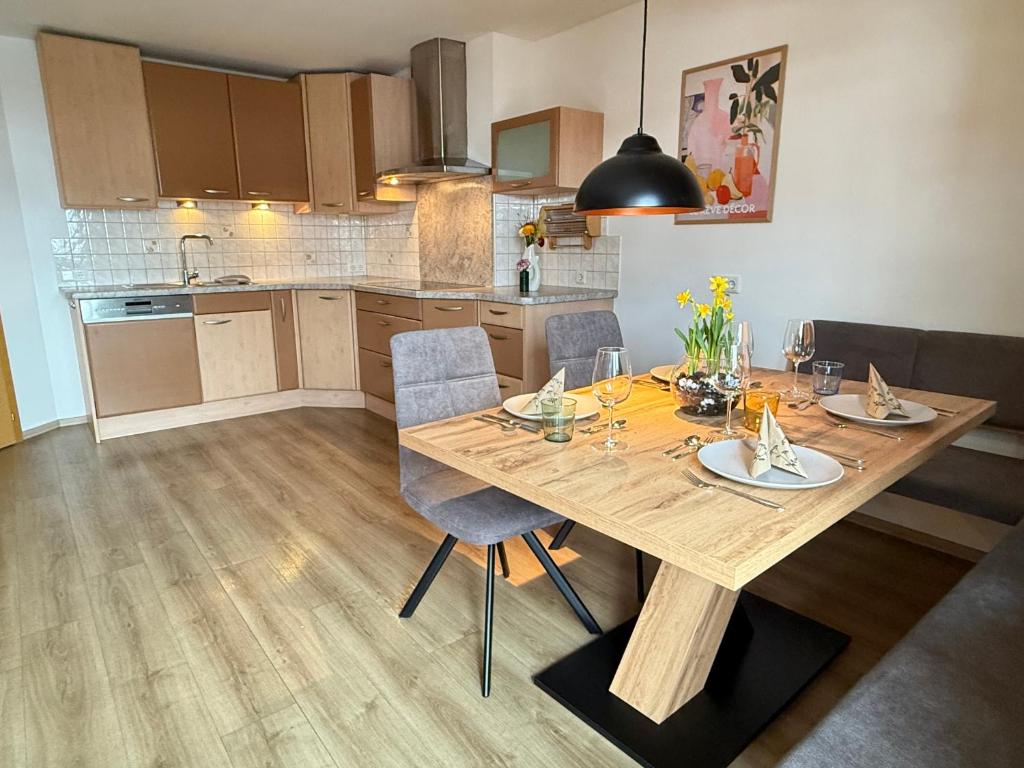 a kitchen with a wooden dining table and chairs at Ferienwohnung Leitacker im Kaiserwinkl in Rettenschöss