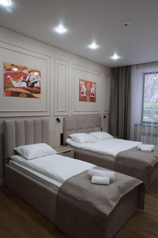 a bedroom with three beds and a window at Кочевник in Semey