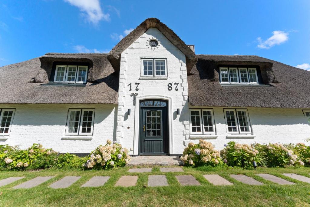 a white house with a thatched roof at Carolinen Hof 1 in Tinnum