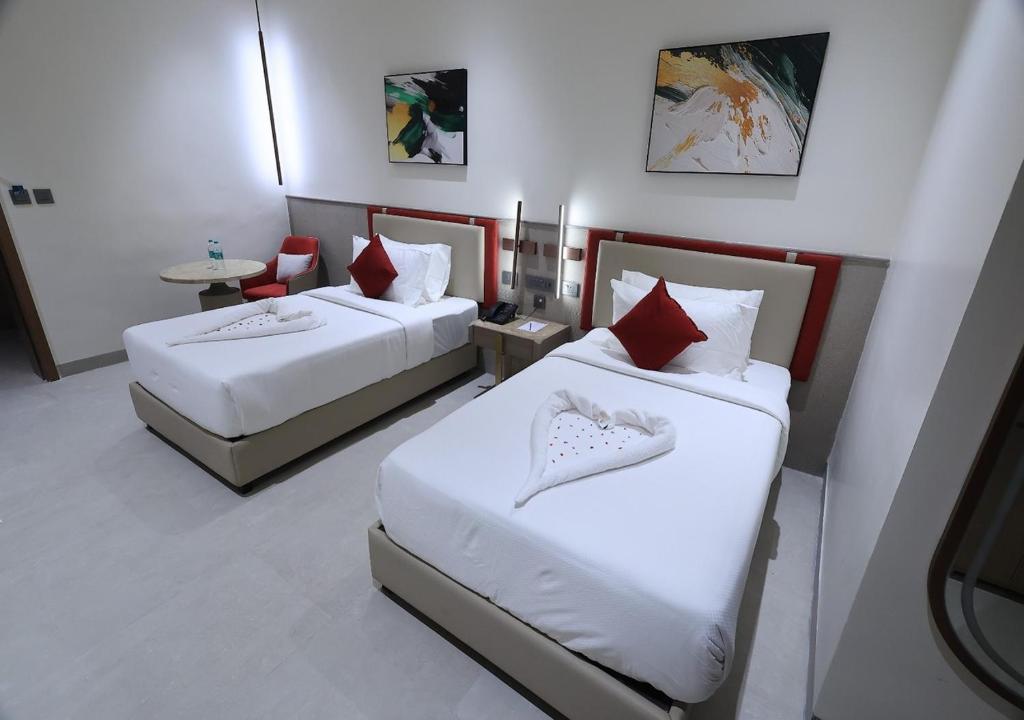 a hotel room with two beds and a table at Antra Luxe in Anumalkudūru