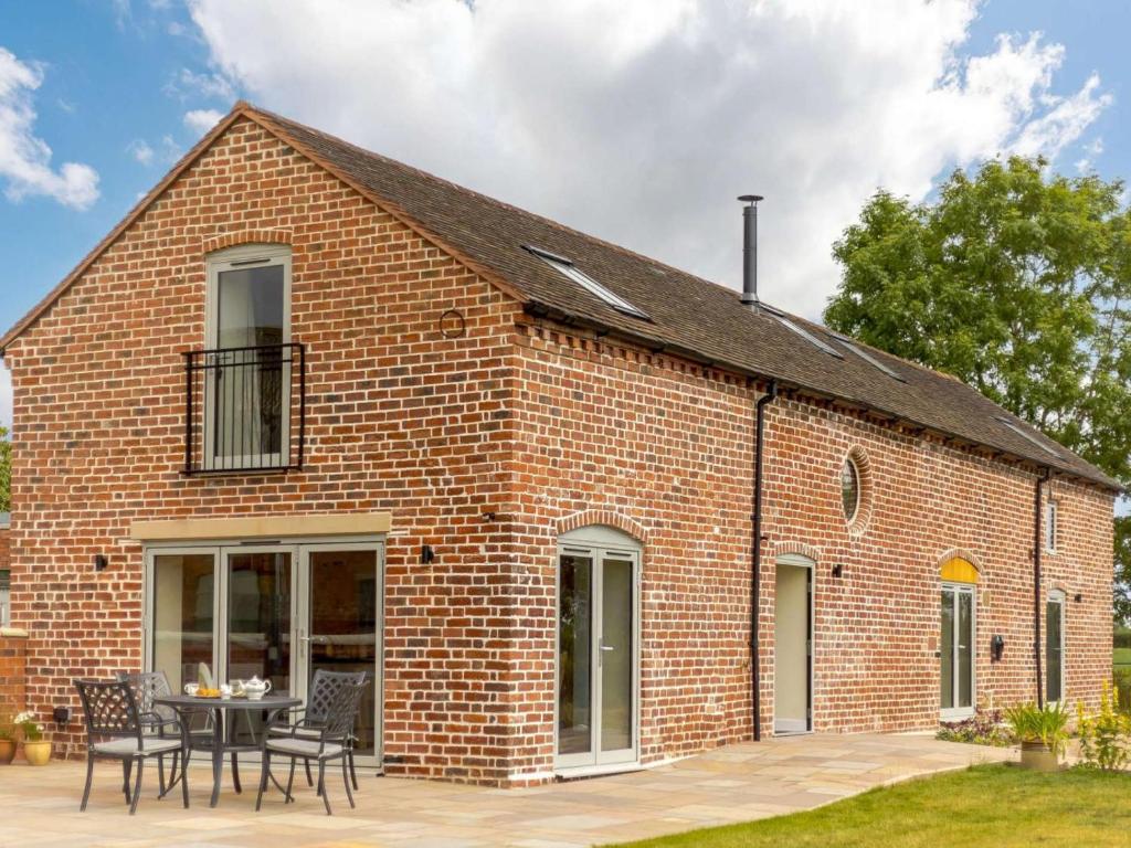 a red brick building with a table and chairs at 3 Bed in Whitchurch oc-88915 in Whixall