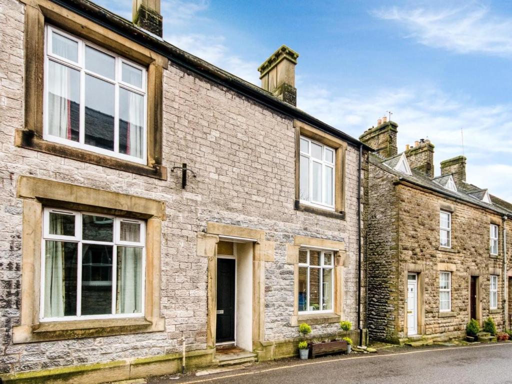 an old brick house with white windows on a street at 3 Bed in Buxton oc-77955 in Tideswell
