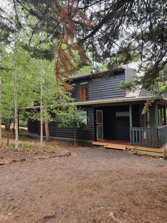 a house with a porch and a yard at Mount Buller Summer & Ski Holiday House The Bower in Merrijig