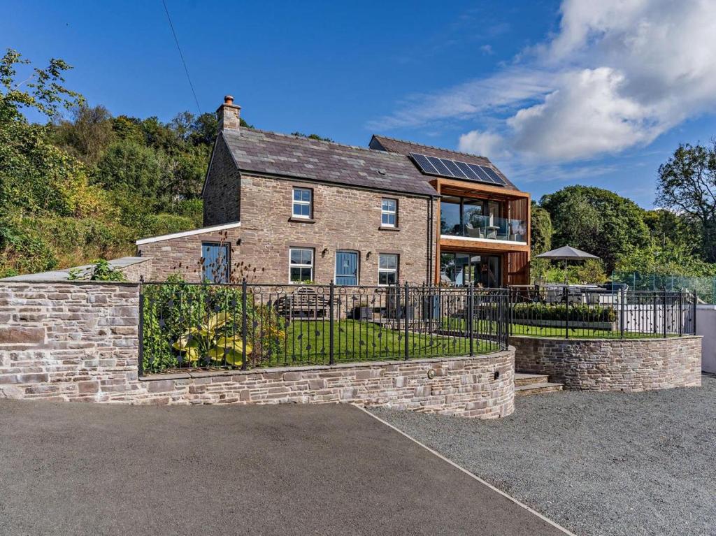 a large brick house with a fence in front of it at 4 Bed in Brecon oc-90596 in Bwlch