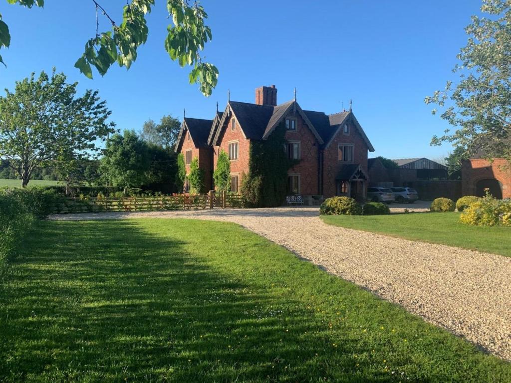 a large brick house with a gravel driveway at 8 Bed in Rugeley oc-79321 in Abbots Bromley