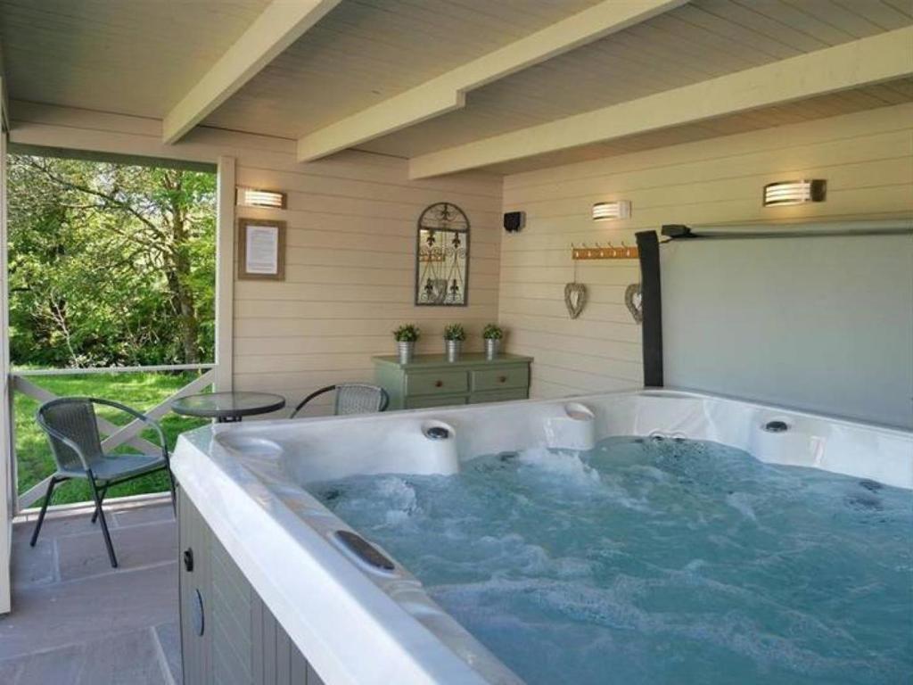 a jacuzzi tub in a room with a table at 4 Bed in Brecon oc-bn151 in Devynock