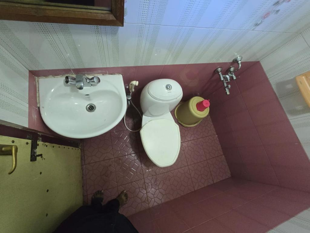a bathroom with a sink and a trash can at Padayappa Residency in Kodaikānāl