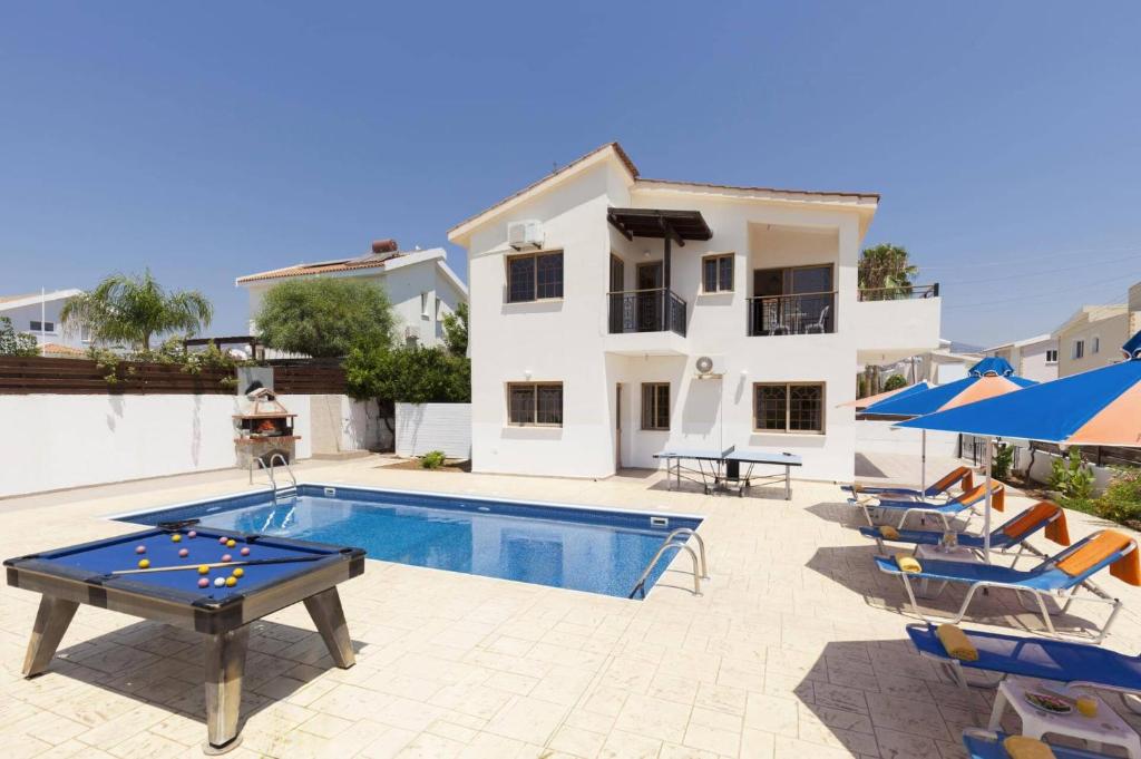 a villa with a swimming pool and patio furniture at Villa Katina by Villa Plus in Peyia