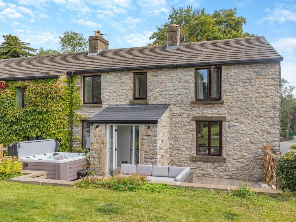 a stone house with a hot tub in the yard at 2 Bed in Hope Valley oc-94552 in Bradwell