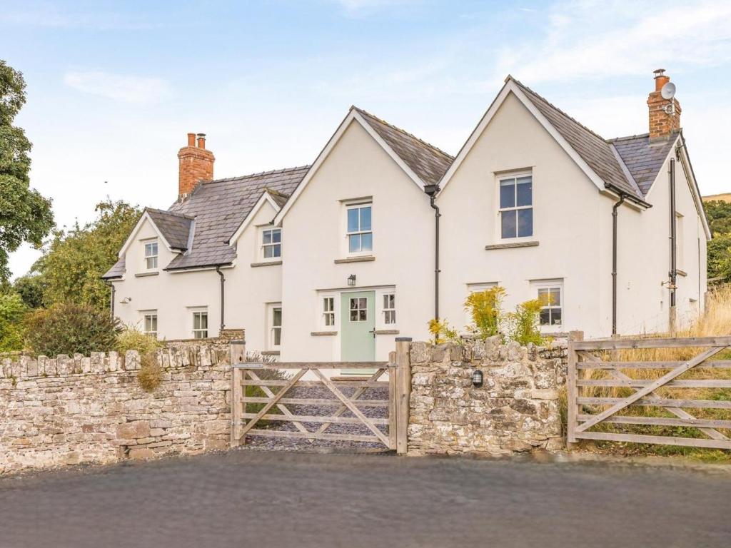 a white house with a fence and a gate at 5 Bed in Crickhowell oc-90053 in Crickhowell