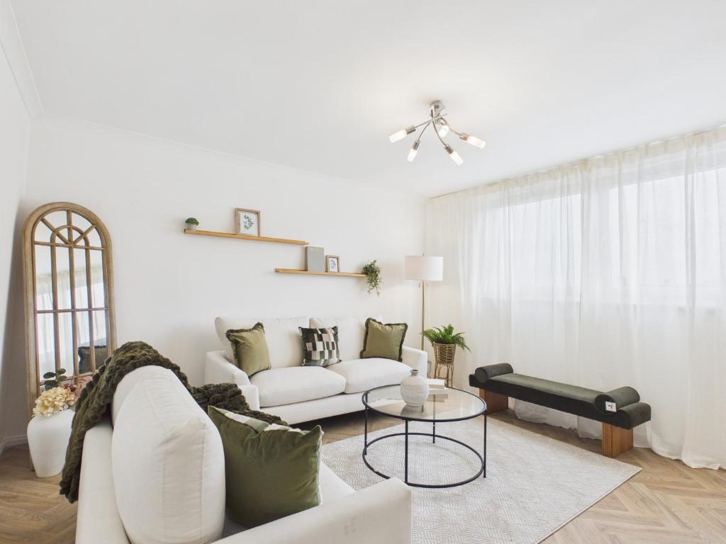 a living room with a white couch and a table at The Bridge View Apartment in Hawick