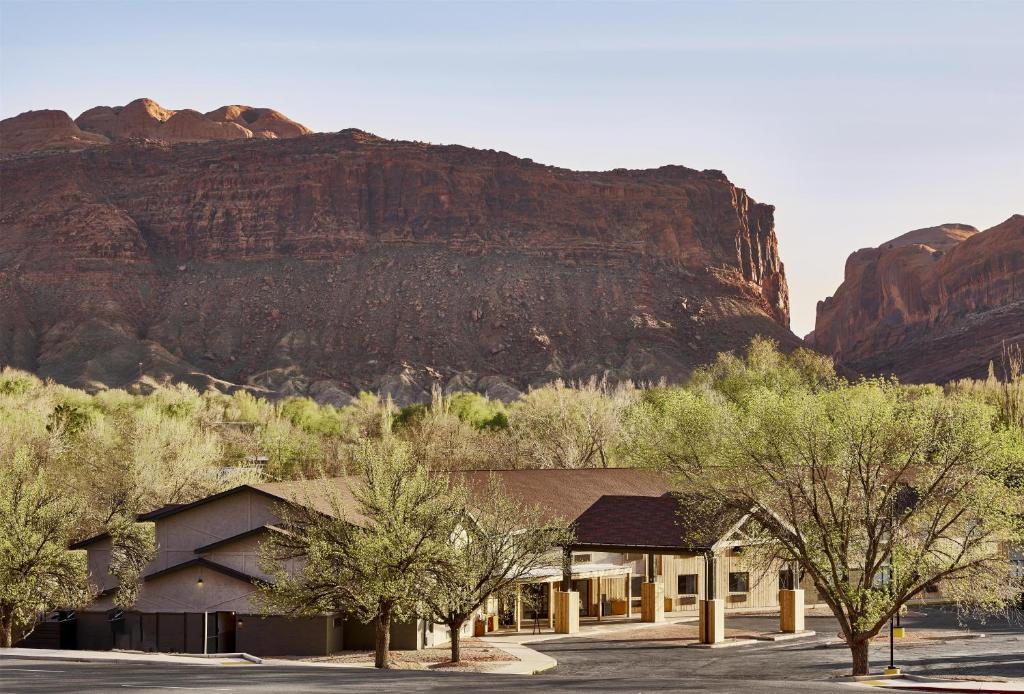 a building in the desert with a mountain in the background at Slackline Moab, Outset Collection by Hilton in Moab