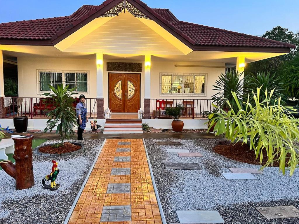 a person standing in front of a house at Baan Farang in Samut Songkhram