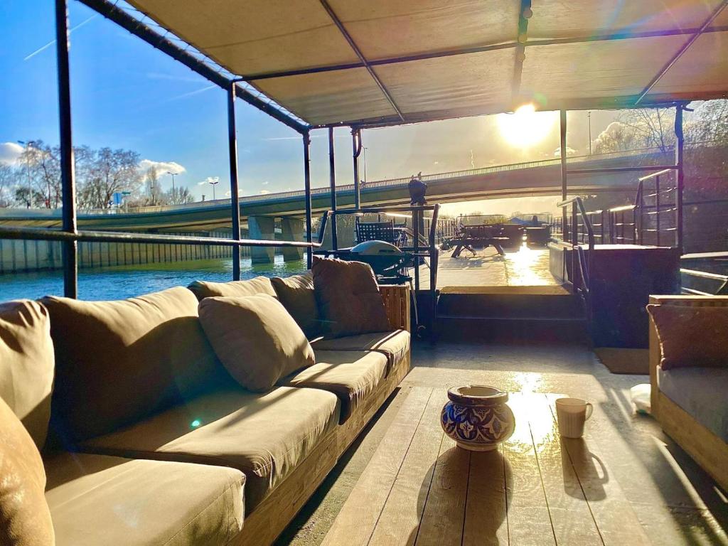 a living room with a large couch on a boat at Grande Péniche Climatisée avec Terrasse - Proche Paris in Puteaux