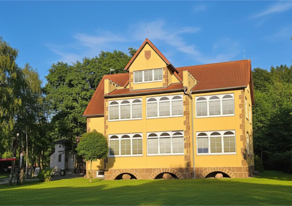 a yellow house with a red roof at Ostsee-Rittergut-Rügen - BinzHotel & OrdensKapelle in Binz
