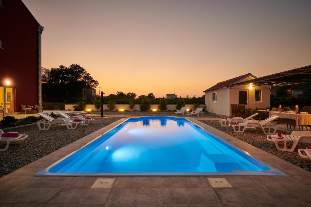 a swimming pool in a backyard at night at Villa Liberty 2 in Cavtat