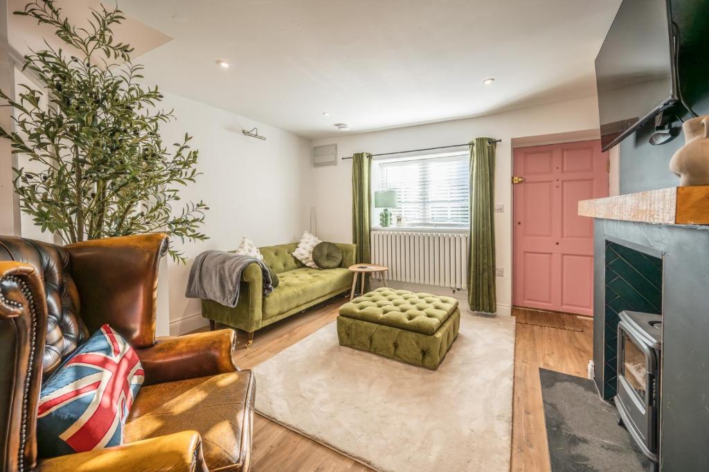 a living room with a couch and a fireplace at Pink Cottage, Leiston in Leiston