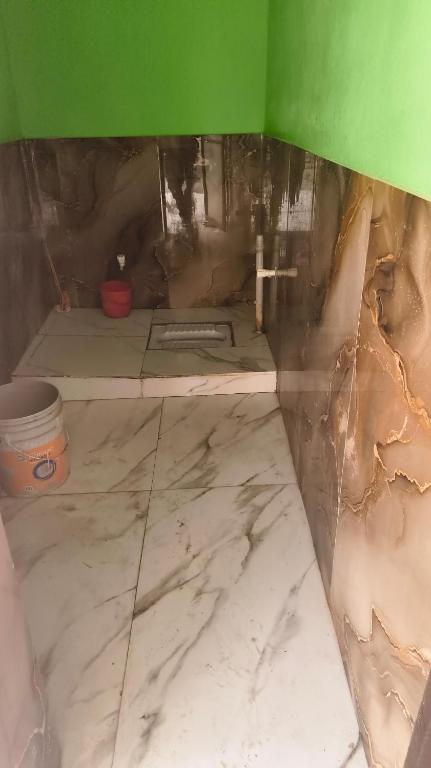 a room being remodeled with marble floors and green walls at Sukhram ji ka awas in Morādābād