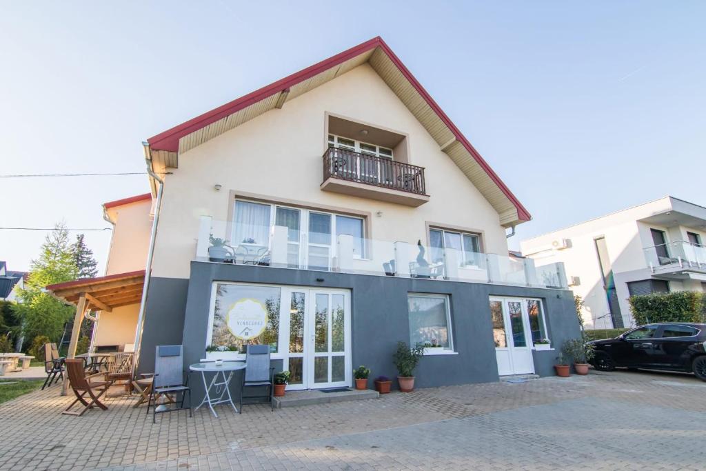 a house with a balcony and a table and chairs at Balkonett Vendégház in Balatonfüred