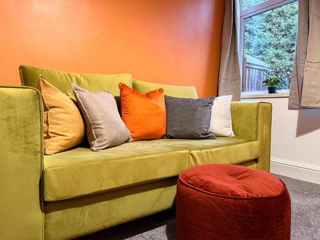 a yellow couch with colorful pillows on it at Contractor Friendly 4 Bed House XBOX Sleeps 6 in Newark-on-Trent