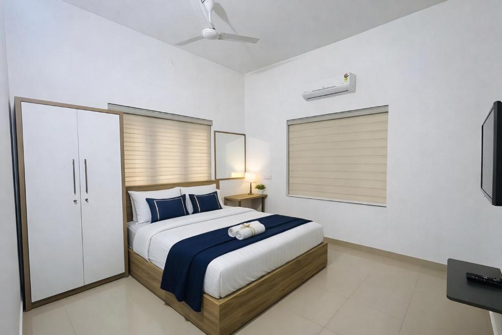 a bedroom with a bed and a television in it at Easy Nest Residency in Kannur