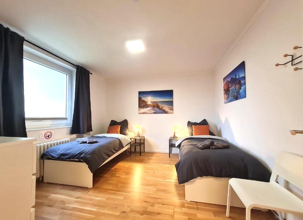 a bedroom with two beds and a window at Moderne Wohnung mit Balkon und top Anbindung in Unna