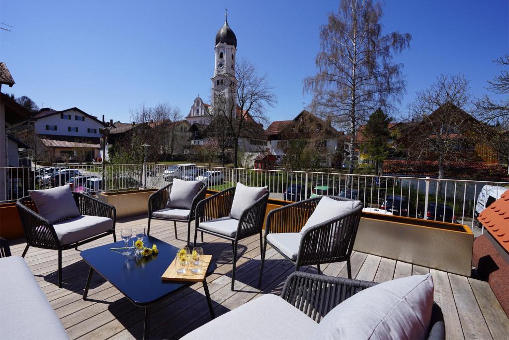a patio with chairs and a table and a clock tower at Villa Primavera in Nesselwang