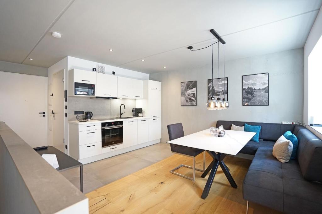 a kitchen and living room with a couch and a table at Exclusive Maisonettewohnung! in Nesselwang