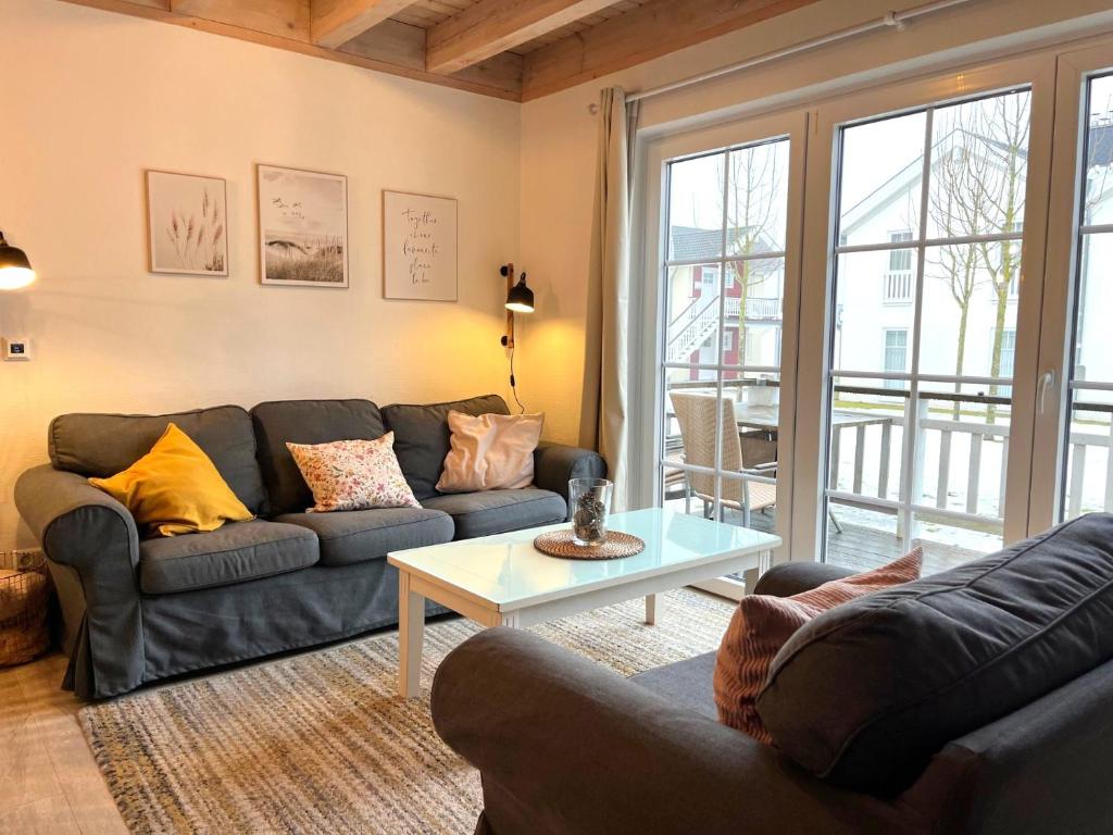 a living room with a couch and a table at Ferienhaus Oceansounds in Sierksdorf