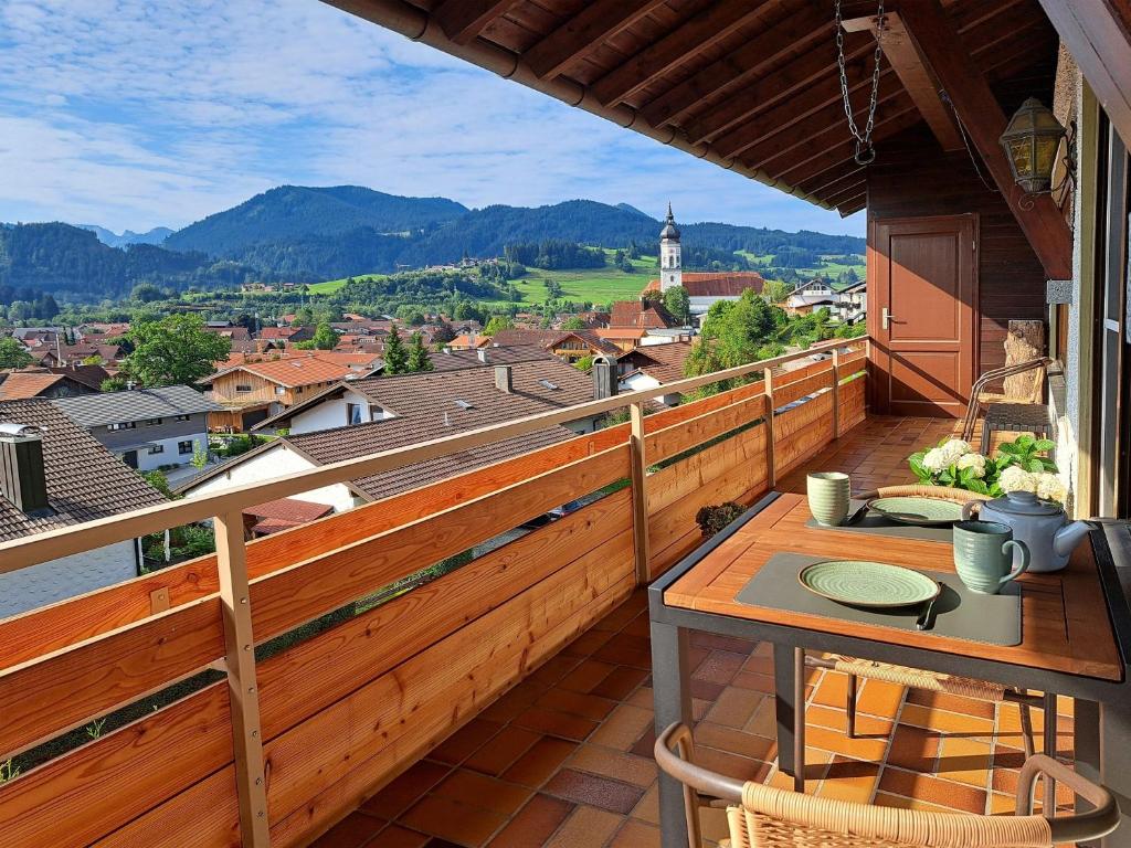 a balcony with a table and a view of a city at Panoramaweg in Wertach