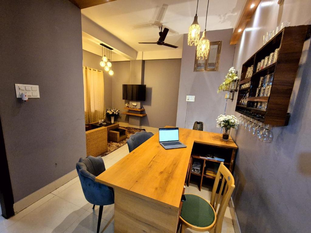 a dining room with a table with a laptop on it at Luxe Haven Homestay 2A in Guwahati