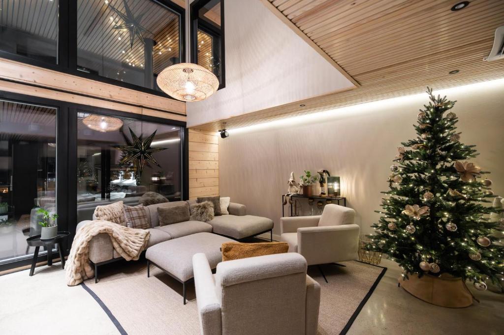 a living room with a christmas tree and a couch at Villa Log modern interior in Rovaniemi