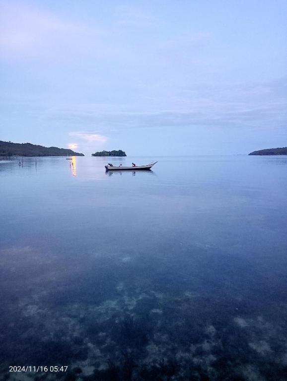 a boat in the middle of a large body of water at War Homestay in Pulau Minyaifuin