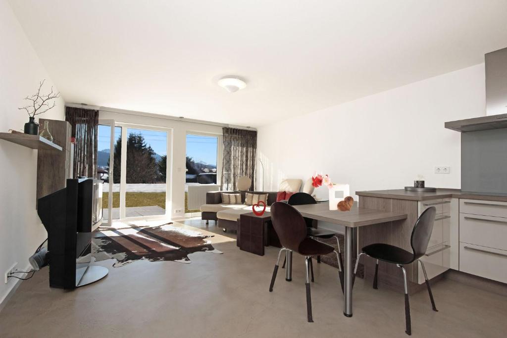 a kitchen and living room with a table and chairs at N-Appartement Falkenstein in Nesselwang