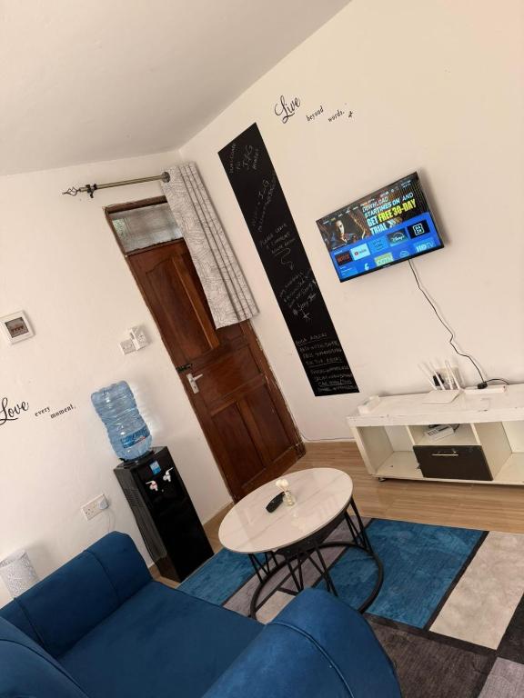 a living room with a blue couch and a table at JnG HOMES in Malindi