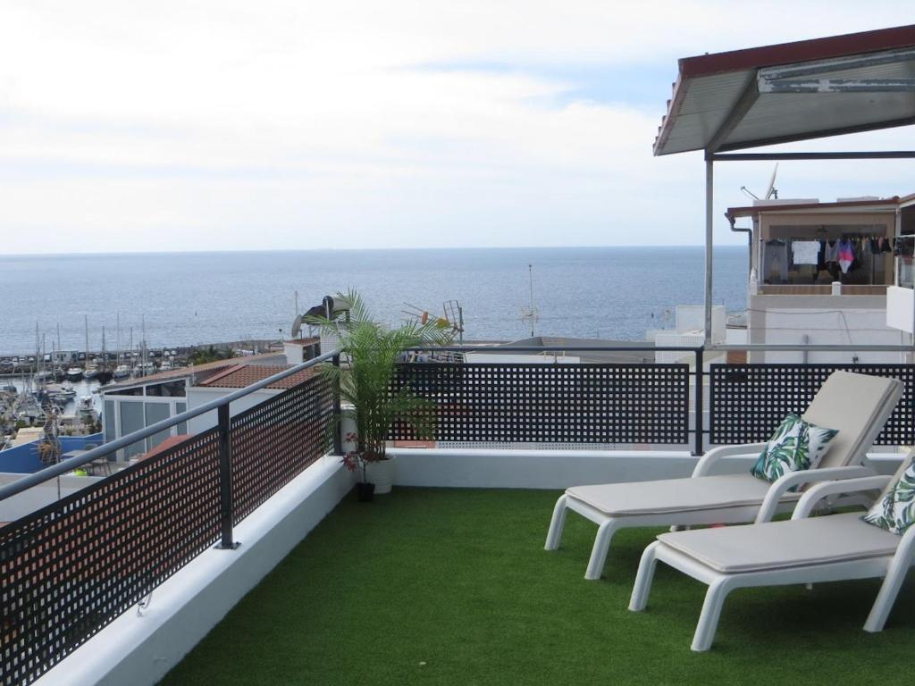 a balcony with chairs and a view of the ocean at Stunning Ocean Views in Puerto de Mogan in Puerto de Mogán