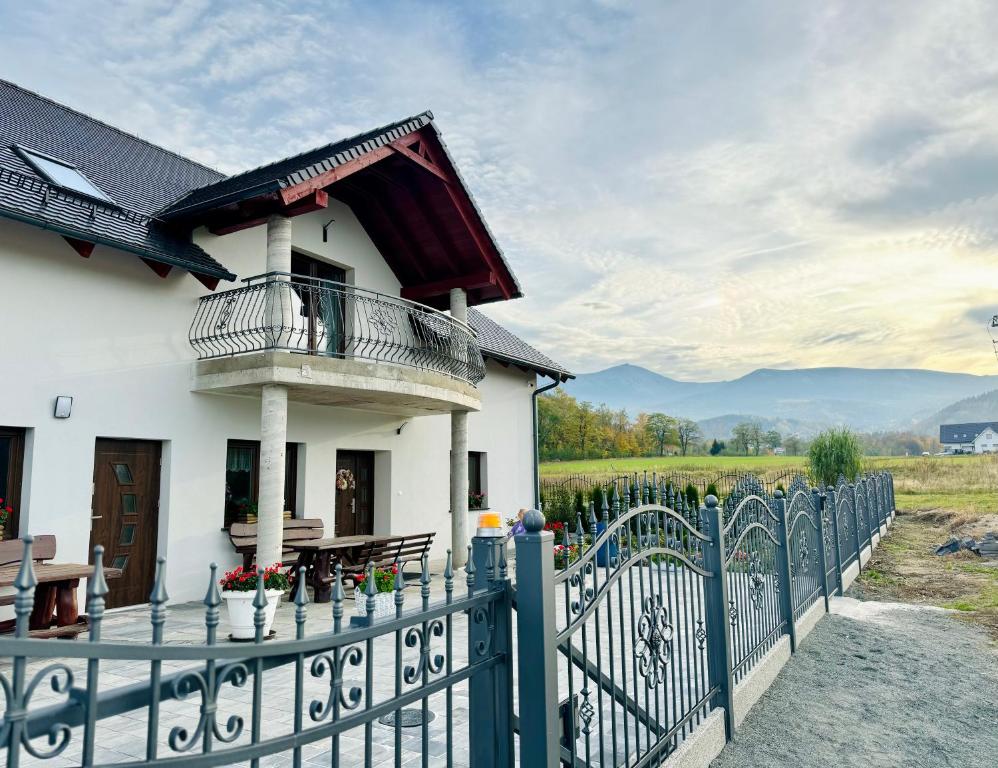 a white house with a fence and a balcony at Willa u Marioli in Ściegny
