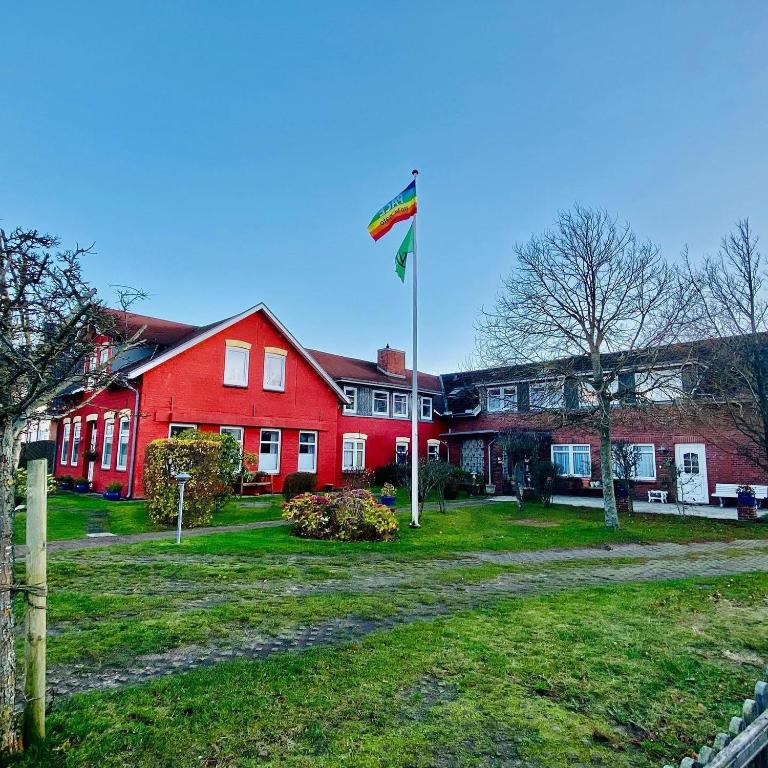 a flag flying in front of a red house at Zum Fahrensmann in Norddorf