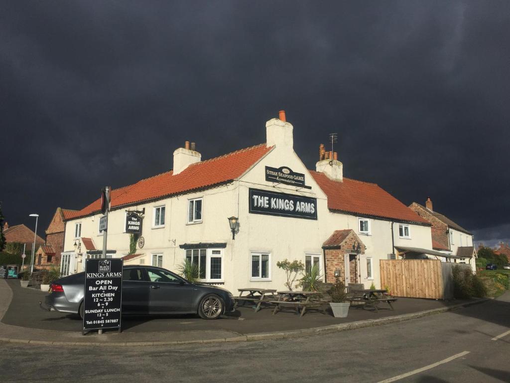 un pub con un coche aparcado delante de él en Kings Arms, en Thirsk