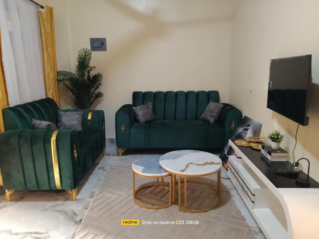 a living room with a green couch and a table at Luxury Homes in Mtwapa