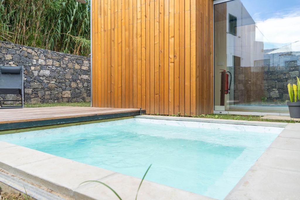a swimming pool in the backyard of a house at Grão de Areia - Mosteiros - 50m da praia - piscina privada in Mosteiros