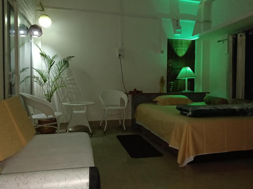a bedroom with a bed and a couch and a table at BiJOY VILLA in Guwahati