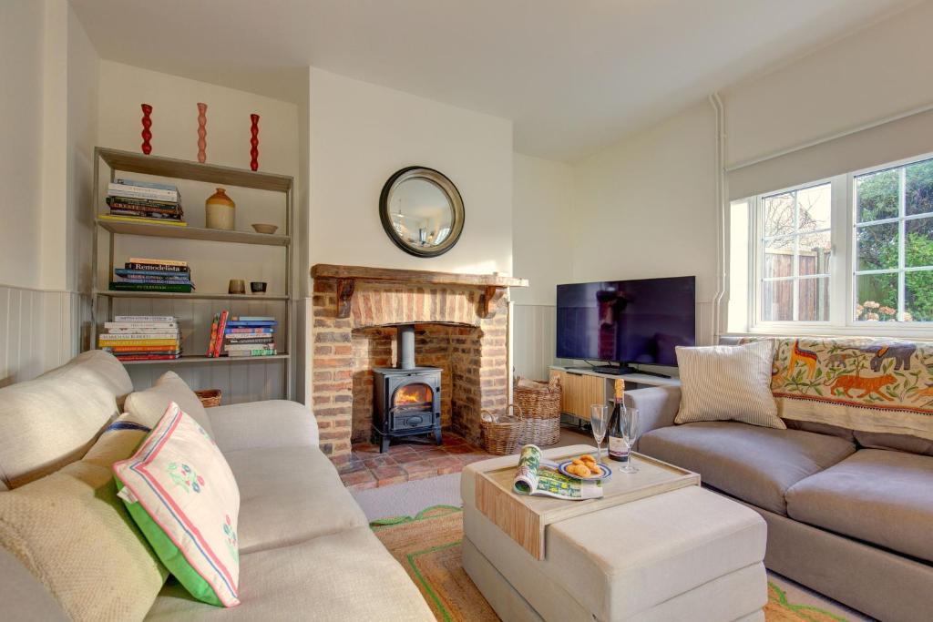 a living room with a couch and a fireplace at Rose Cottage in Docking