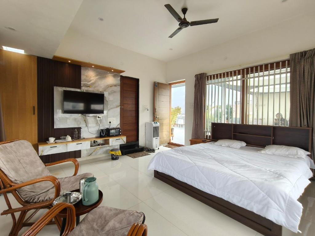 a bedroom with a large bed with a ceiling fan at Aavasan home stay with AC in Dāvangere