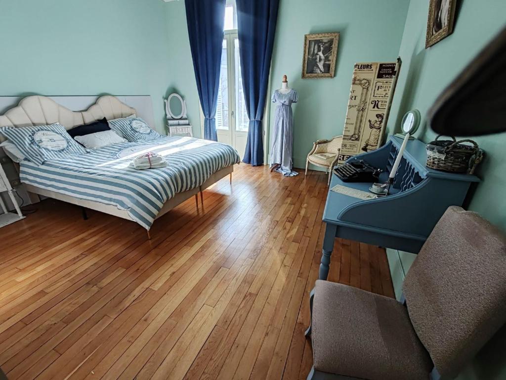 a bedroom with a bed and a wooden floor at Chez Madame in Dijon