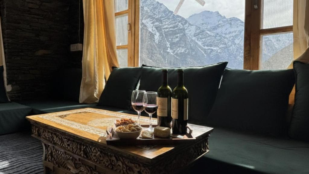a table with wine bottles and glasses on a couch at Julley Jispa in Jispa
